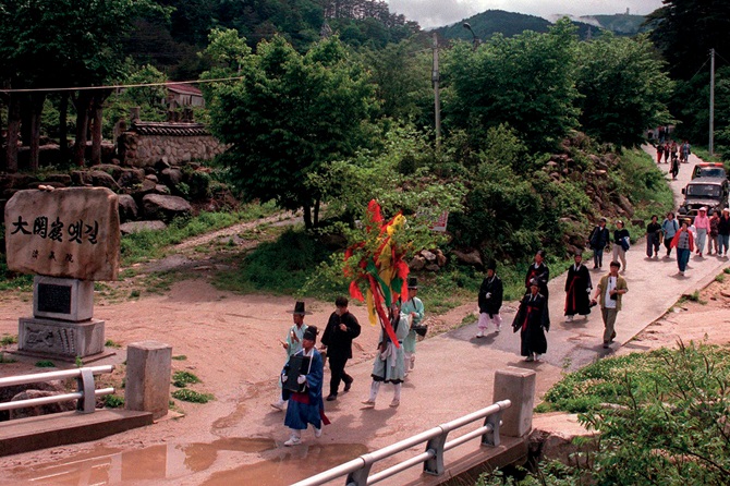 강릉 단오제에서 사람들이 대관령산신제를 지내고 위패를 들고 강릉시내로 가고 있다.  
