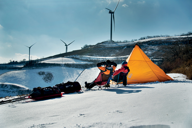 눈밭에 앉아 풍력발전기를 바라보며 망중한을 즐기고 있다. 


