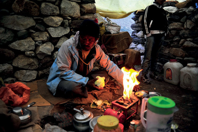 여행자를 위한 휴게소인 다바의 주인이 음식을 만들기 위해 불을 켜고 있다.