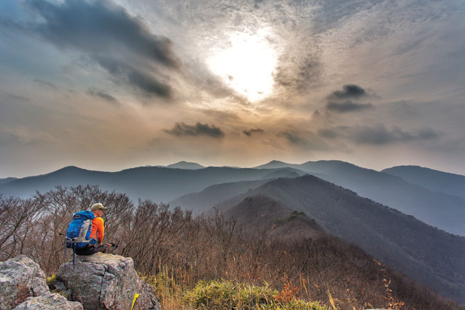 공단 김민씨가 낙조대에 앉아 첩첩산중 변산의 산그리메를 바라보고 있다.