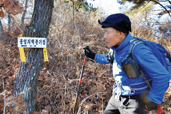 무량산에서 철마봉으로 내려서는 능선 길에 걸린 팻말을 바라보는 김태영 선생.