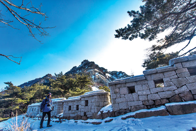 북한산성 성곽을 보며 산성길을 따라 걷고 있다.