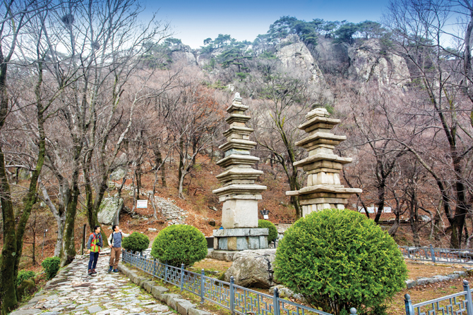 보물로 지정된 남매탑 뒤로 계룡산의 암벽 봉우리들이 우뚝 솟아 있다.