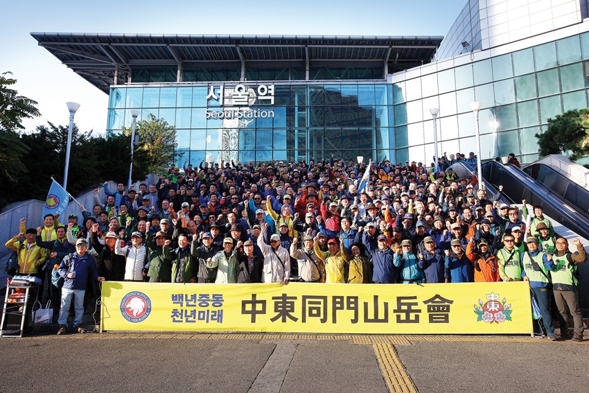 중동고 동문산악회원들이 서울역 광장 계단을 가득 채워 기념사진을 찍고 있다.