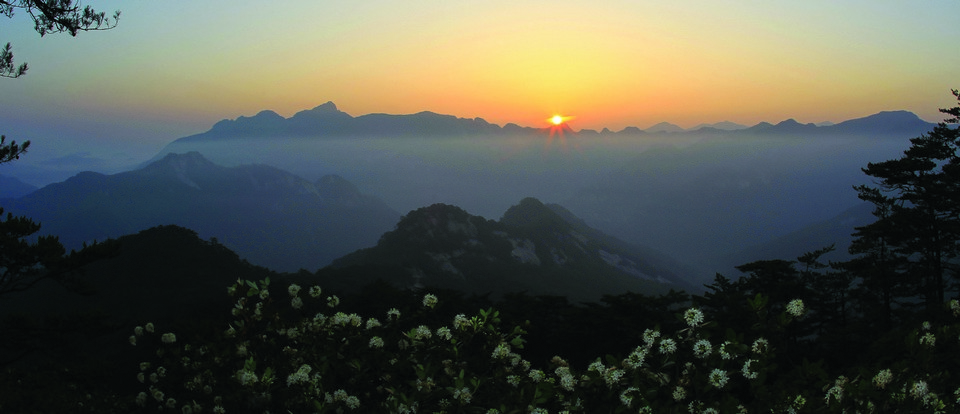 한국의 대표적인 악산에 속하는 월악산에 저멀리 능선 너머로 해가 떠오르고 있다.