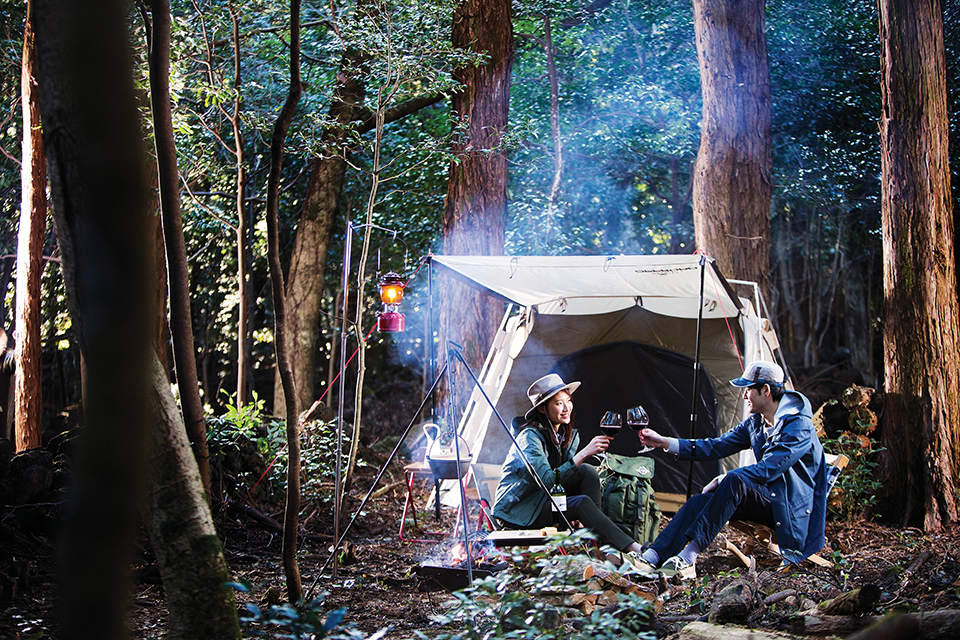 숲 속의 작은 공터에서 미니멀 캠핑을 즐기는 사람들.