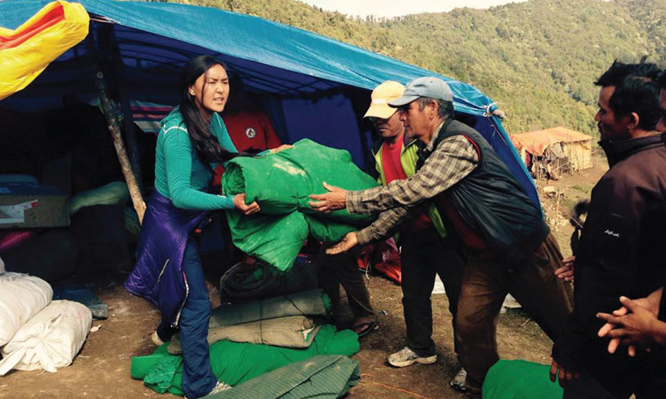 파상 라무 셰르파 아키타가 네팔 대지진으로 피해를 입은 지역에 구호물품을 나눠 주고 있다. 사진 셰르파어드벤처기어.