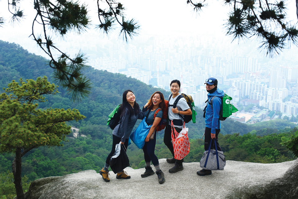 불암산 전망바위에서 서울 시내를 배경으로 선 클린하이커스 회원들.