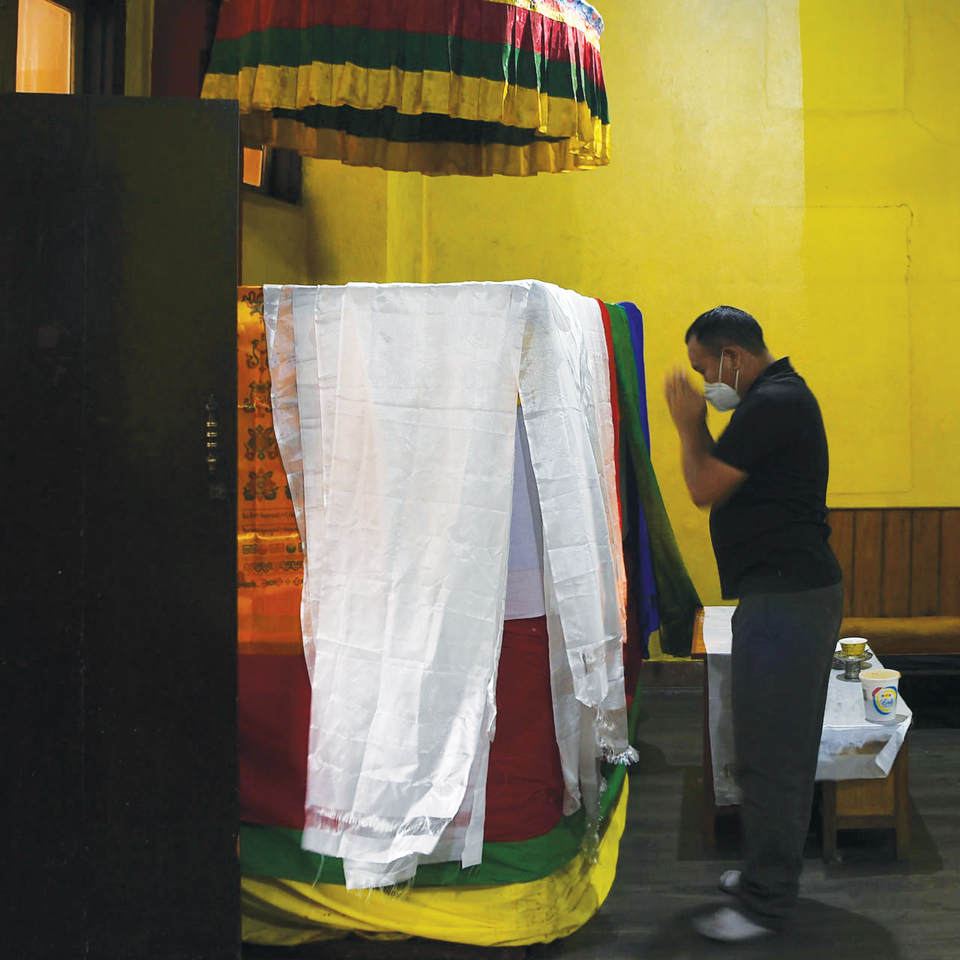  한 조문객이 앙 리타 셰르파의 시신이 담긴 관 앞에서 절을 올리고 있다. 사진 프랑스24