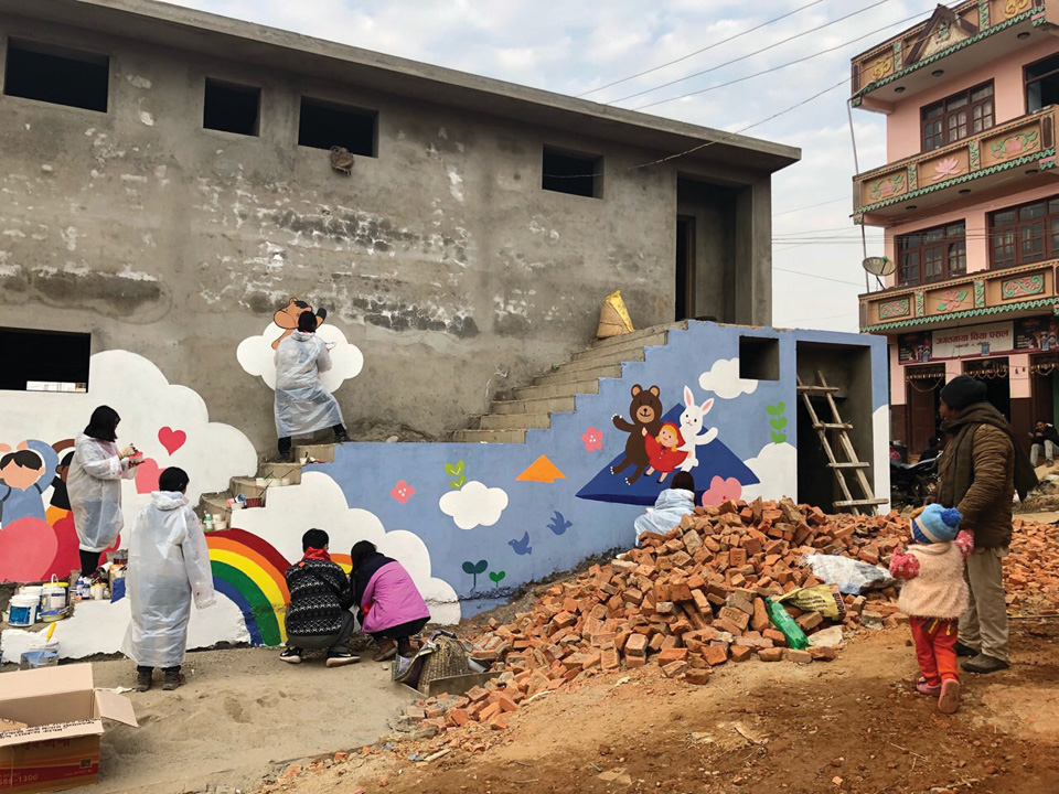 낡은 네팔 학교의 담을 벽화로 채색하는 학생들. 