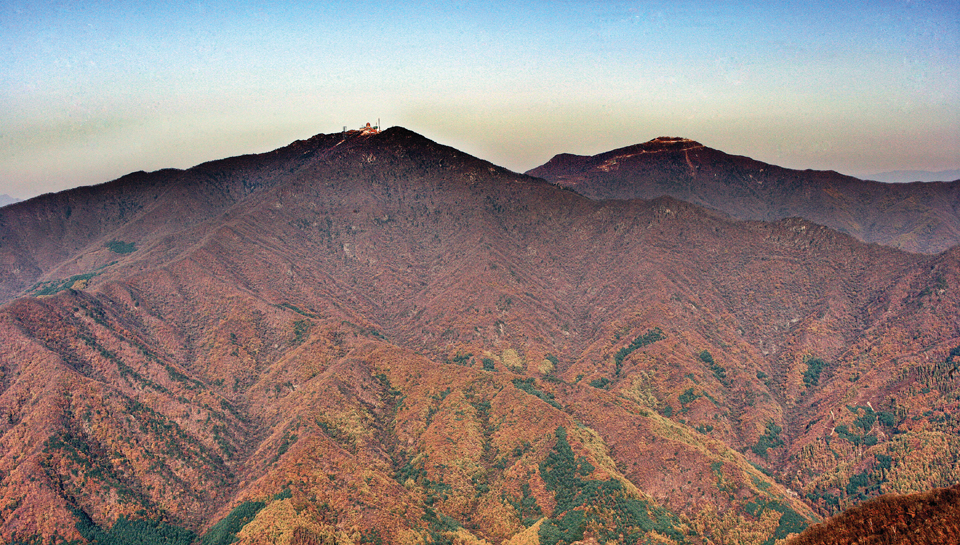 명지산에서 바라본 화악산 정상에는 군부대(사진 중앙)가 있고, 오른쪽 응봉까지 군사도로가 연결돼 있다. 사진 C영상미디어