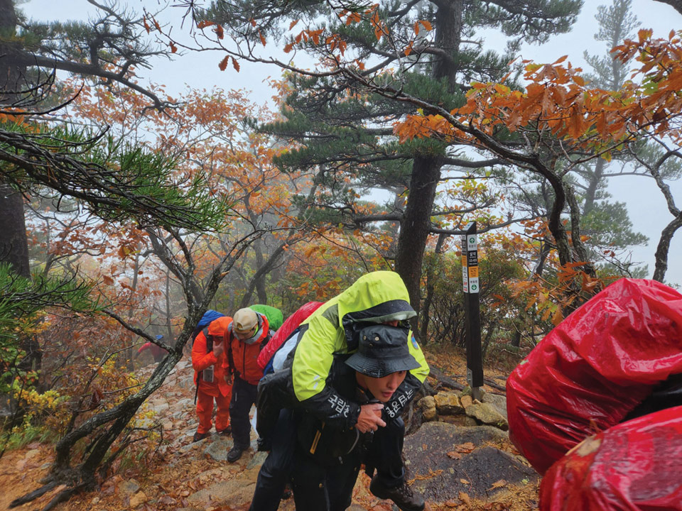 80세 A씨를 업고 오세암으로 향하는 구조대원들.