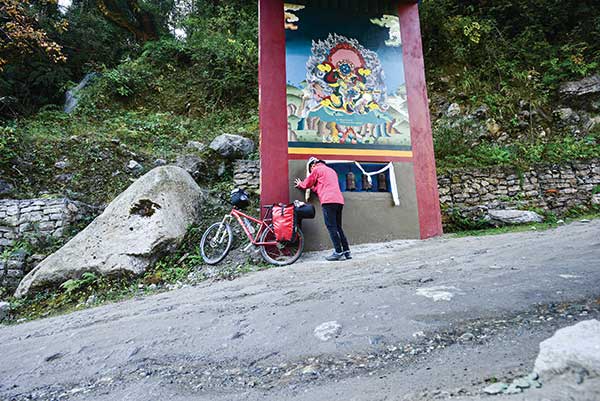 마을 입구를 표시하는 문. 불교 수행자인 요기 그림 아래에는 손으로 돌릴 수 있도록 만든 불경 마니차가 있다.