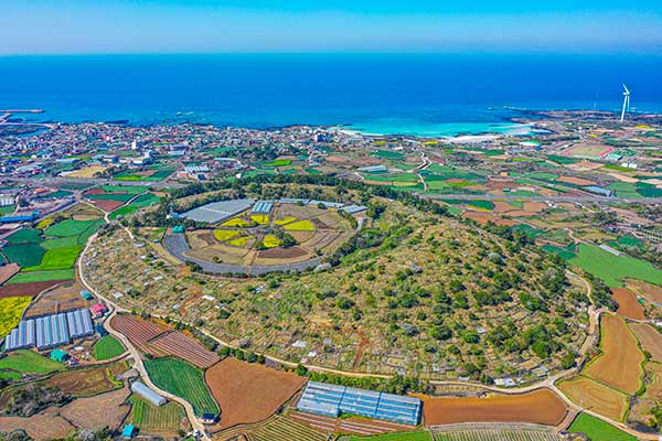 남쪽 하늘에서 본 삿갓오름. 멀리 김녕해수욕장이 보인다.