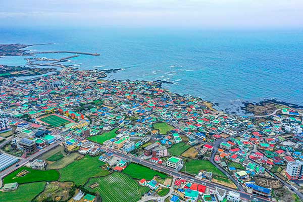 정상에서 본 김녕항과 김녕리. 대부분 이곳에 묻힌 이들의 후손일 것이다.