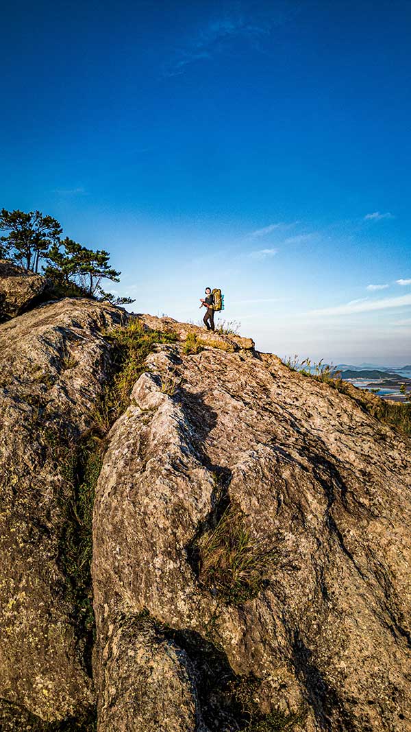 거대한 암릉으로 이뤄진 그림산 능선 위에 홀로 서서 바다 위로 떨어지는 석양을 바라보고 있다.